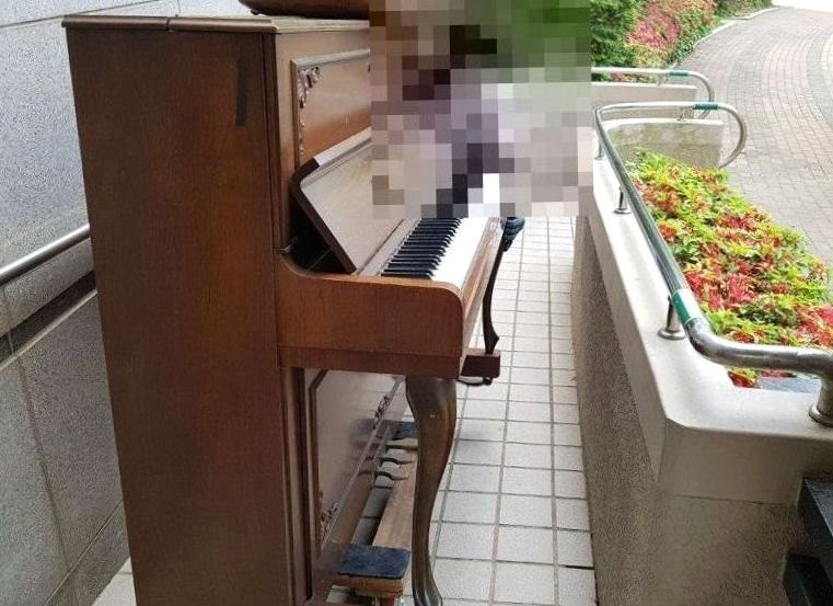 단지 안 통로를 따라 운반 받침으로 옮기는 업라이트 피아노