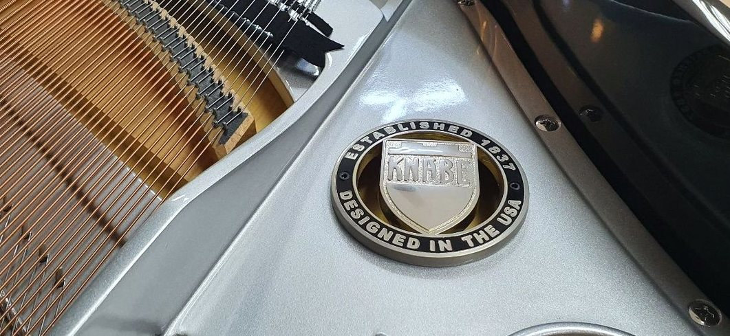 그랜드 피아노 프레임에 붙은 브랜드 원형 엠블럼